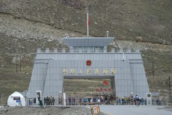 Un ciclista pakistaní (derecha) pasa por el paso fronterizo entre Pakistán y China de Khunjerab, la frontera pavimentada más alta del mundo, durante el Tour de Khunjerab, una de las competiciones ciclistas a mayor altitud del mundo, el 30 de junio de 2019. (Aamir Qureshi/AFP a través de Getty Images)