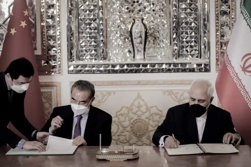 El ministro de Asuntos Exteriores iraní, Mohammad Javad Zarif (derecha), y su homólogo chino, Wang Yi (centro), firman un acuerdo en la capital, Teherán (Irán), el 27 de marzo de 2021. China e Irán firmaron en 2021 el Programa de Cooperación Irán-China para 25 años, una alianza que, según algunos analistas, profundiza la dependencia económica de Irán respecto a Beijing. (AFP vía Getty Images)