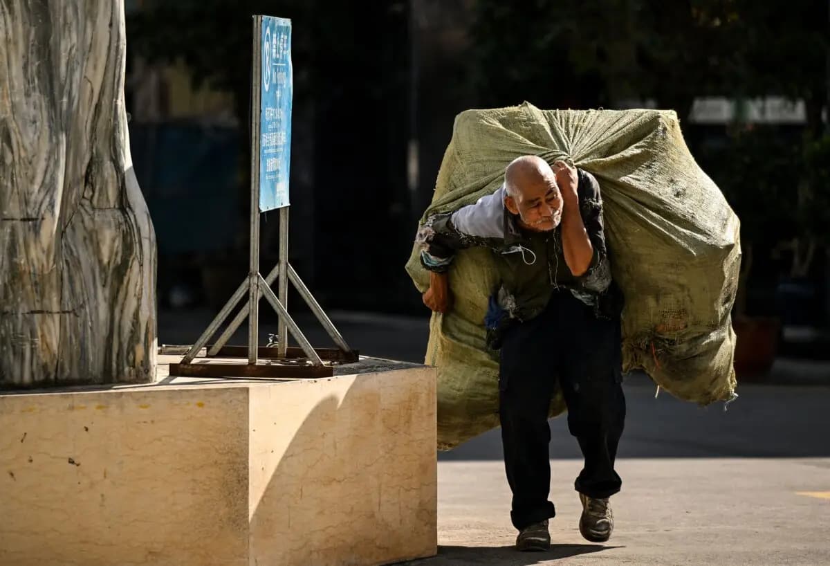 Un anciano lleva una bolsa de materiales reciclables a la espalda en Ruili, al oeste de la provincia de Yunnan, en China, el 13 de enero de 2023. (Noel Celis/AFP a través de Getty Images).