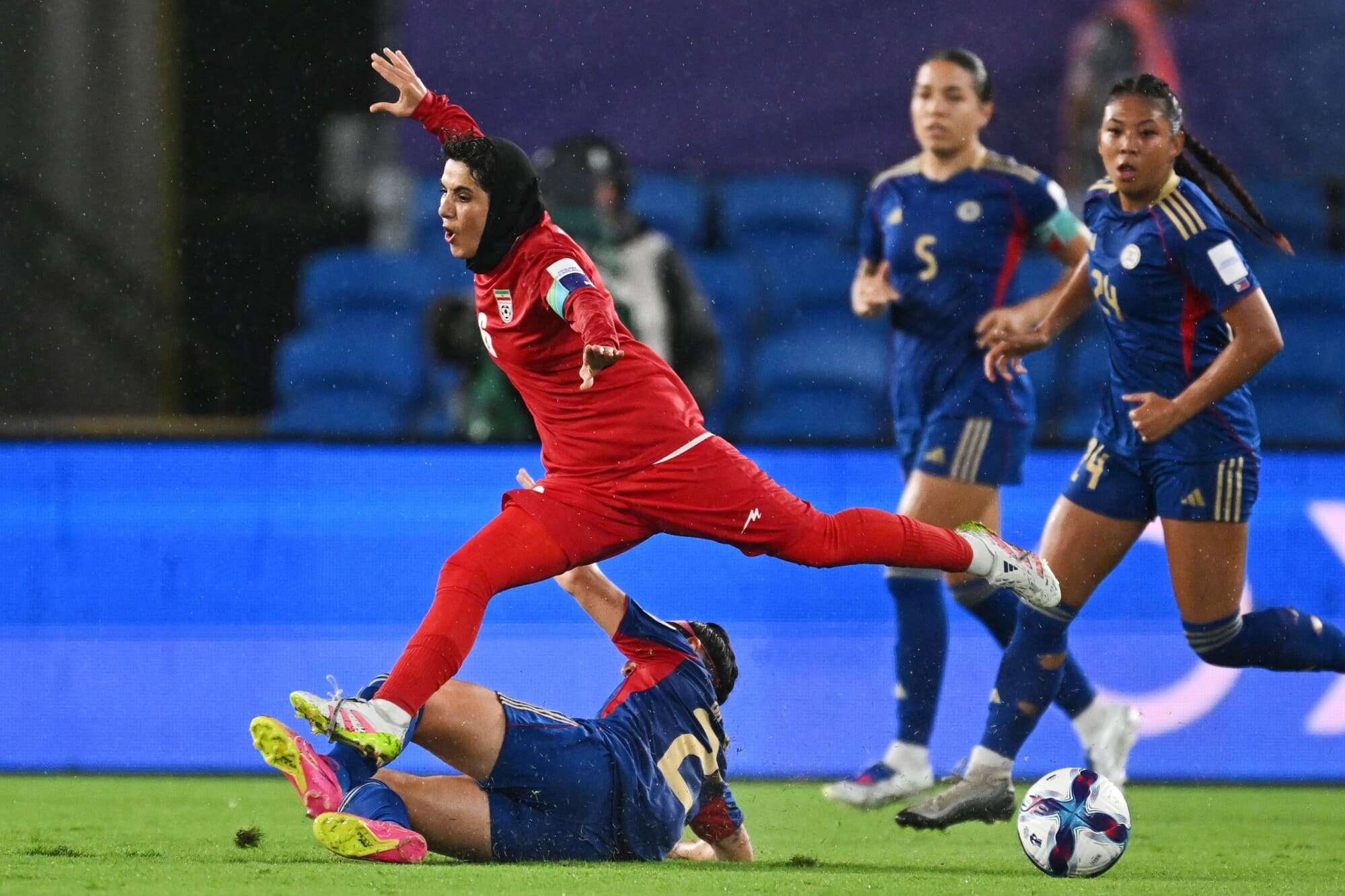 Zahra Sarbali, de Irán, arriba, y Malea Cesar, de Filipinas, luchan por el balón durante el partido de fútbol de la Copa Asiática Femenina entre Irán y Filipinas en Robina, Australia, el 8 de marzo de 2026. (Dave Hunt/AAP Image vía AP).