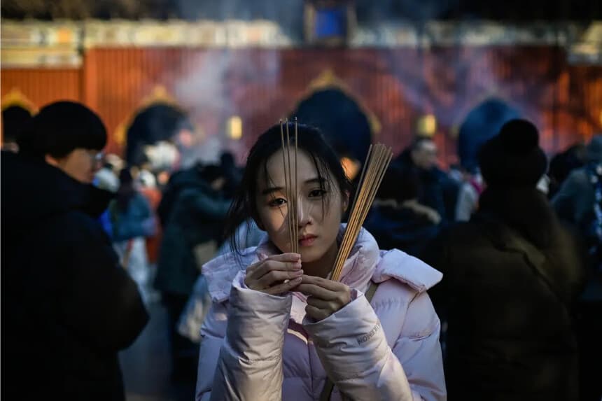 Una mujer quema varillas de incienso y ofrece oraciones en el Templo Yonghe, también conocido como Templo Lama, el primer día del nuevo año en Beijing, el 1 de enero de 2026. (ang Zhao/AFP vía Getty Images)
