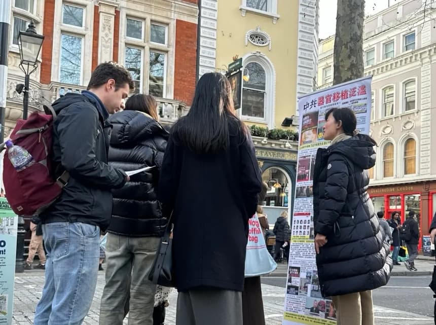 Zhang Chunping (derecha) habla con turistas junto a un cartel sobre la sustracción forzada de órganos en China, cerca del Museo Británico de Londres. (Cortesía de Zhang Chunping)