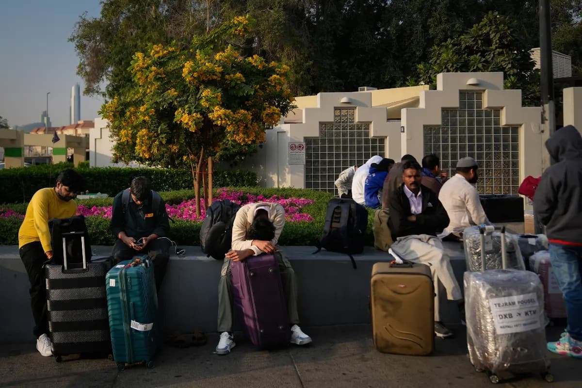 Los pasajeros varados por el cierre del Aeropuerto Internacional de Dubái esperan asistencia en el estacionamiento del aeropuerto de Dubái, Emiratos Árabes Unidos, el 1 de marzo de 2026. (Altaf Qadri/AP)