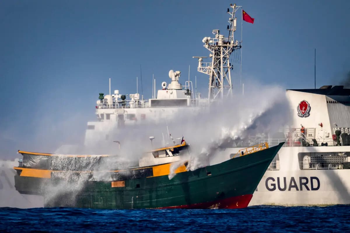 Un barco de la Guardia Costera china dispara un cañón de agua contra el Unaizah, un buque fletado por la Armada filipina, que realizaba una misión rutinaria de reabastecimiento a las tropas estacionadas en el Segundo Banco Thomas, en el Mar de China Meridional, el 5 de marzo de 2024. (Ezra Acayan/Getty Images)