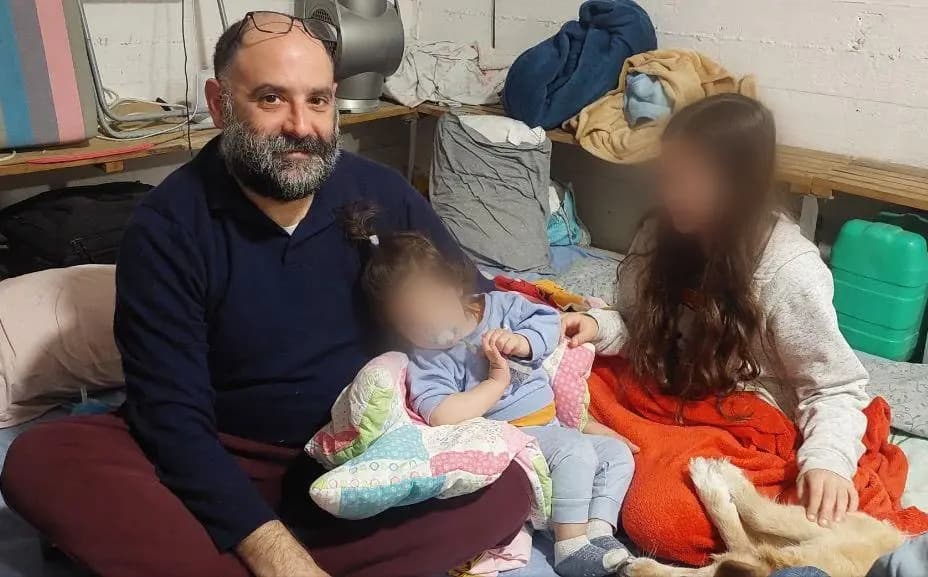 Eitan y sus hijos se resguardan en un refugio israelí ante un posible ataque con misiles iraníes. (Esta imagen fue alterada digitalmente para ocultar la identidad de los niños). (Rachel Berestetsky)