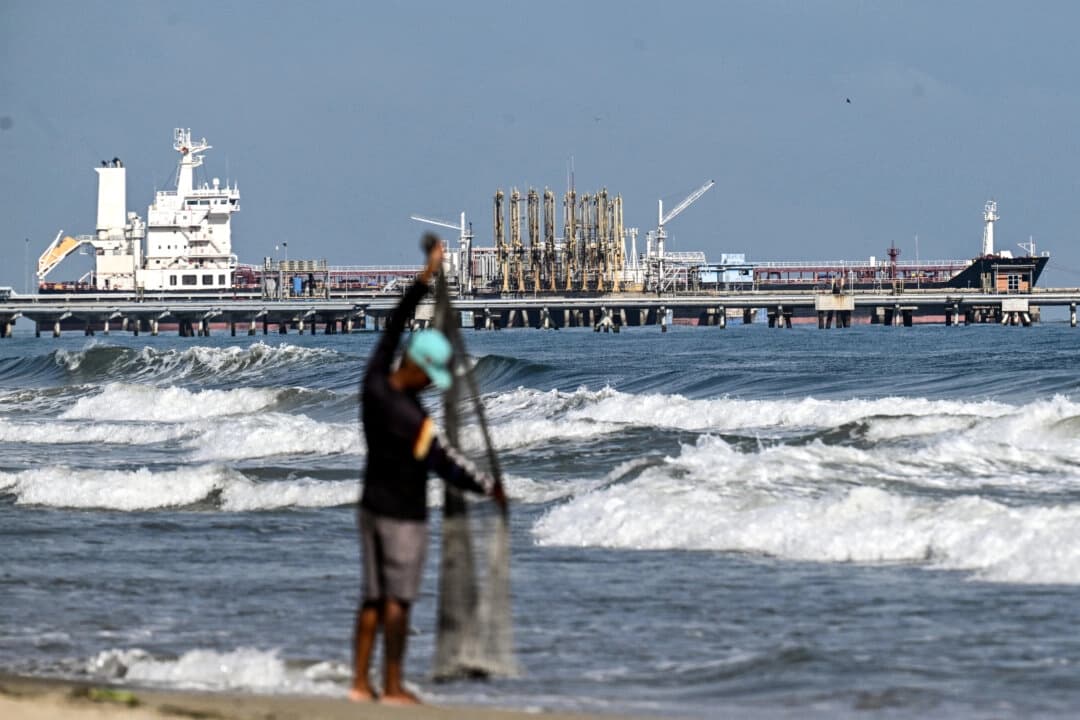 <em>Un pescador permanece junto al mar mientras un buque cisterna atraca en el muelle de la refinería El Palito, en Puerto Cabello, estado Carabobo, Venezuela, el 22 de enero de 2026. (Ronaldo Schemidt /AFP vía Getty Images)</em>
