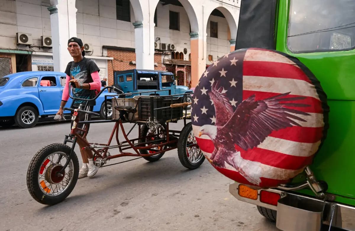 <em>Un hombre empuja un triciclo junto a un jeep con una cubierta de rueda que muestra la imagen de la bandera estadounidense en La Habana, el 23 de enero de 2026. (Yamil Lage/AFP vía Getty Images).</em>