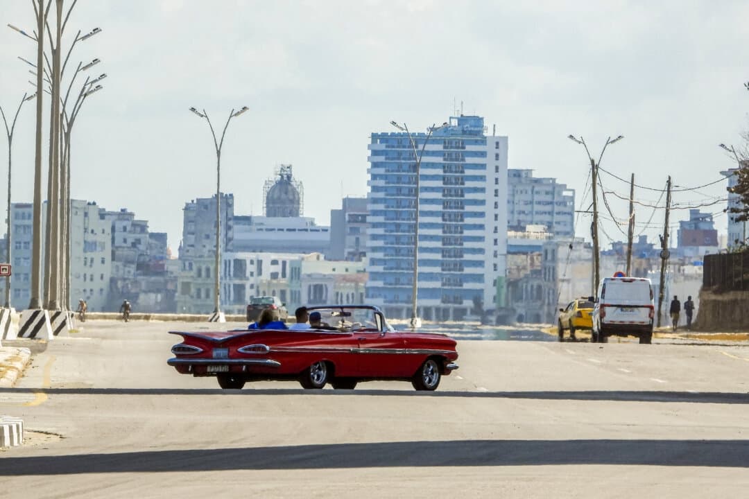 <em>Turistas viajan en un viejo automóvil estadounidense usado como taxi por una tranquila avenida de La Habana el 8 de febrero de 2026. (Adalberto Roque/AFP vía Getty Images).</em>