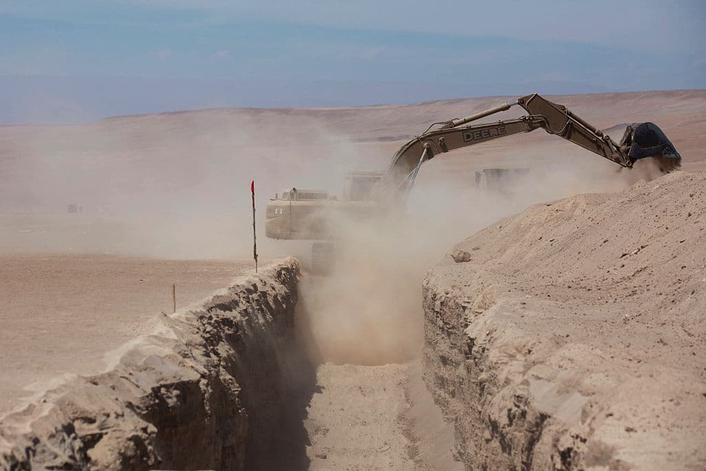 <em>Maquinaria pesada trabaja cerca del puesto fronterizo de Chacalluta, en la frontera entre Chile y Perú, el 16 de marzo de 2026. (Patricio BANDA / AFP vía Getty Images)</em>