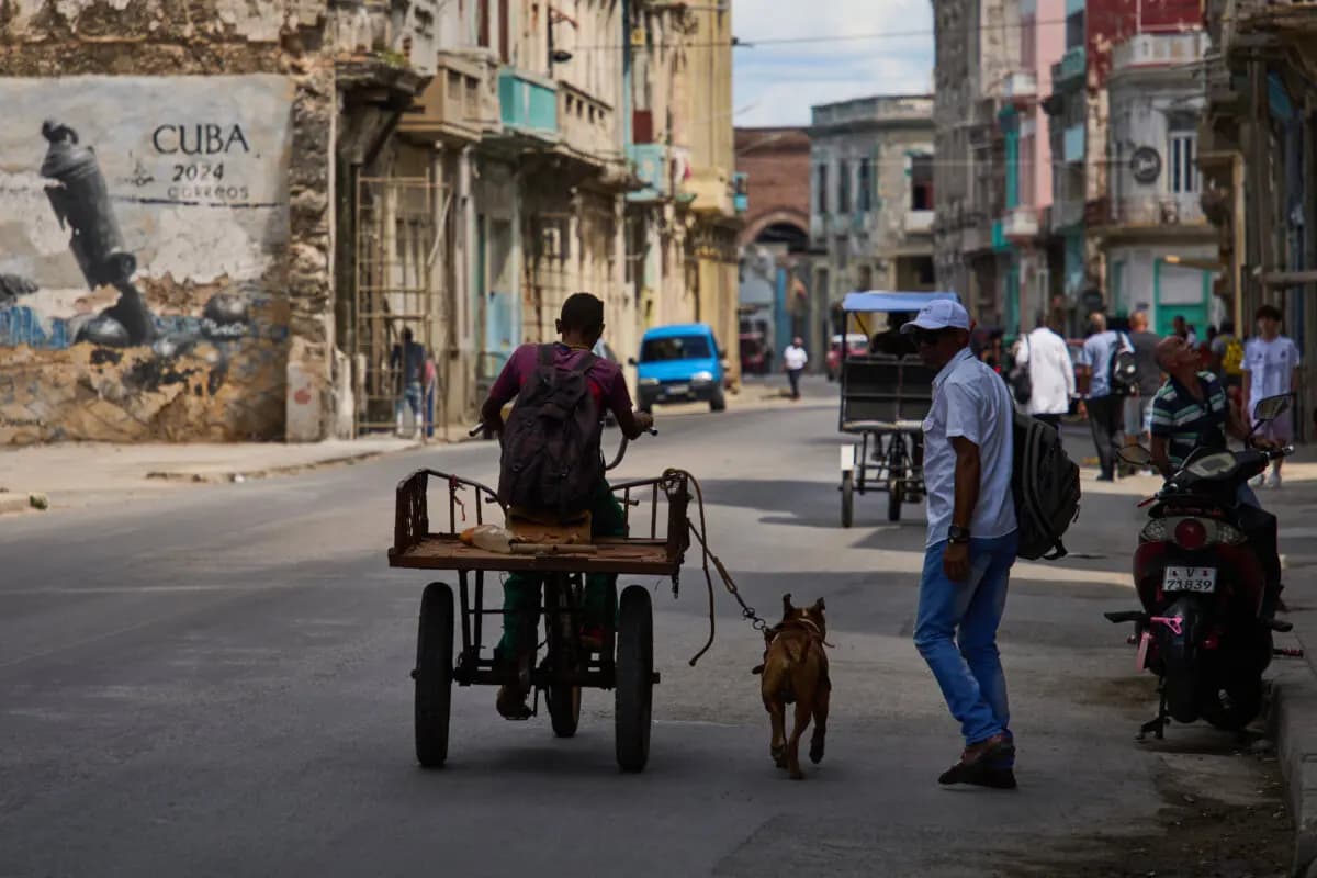 <em>Un hombre monta en triciclo con su perro atado con una correa corriendo a su lado durante un apagón en La Habana, Cuba, el 16 de marzo de 2026. (Ramón Espinosa/Foto de AP)</em>