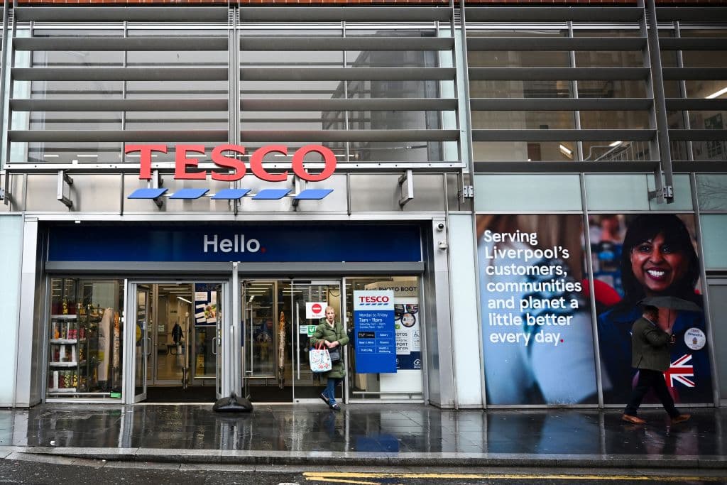 <em>Los clientes salen de un supermercado Tesco en Liverpool, al norte de Inglaterra, el 10 de abril de 2024. (PAUL ELLIS/AFP vía Getty Images)</em>