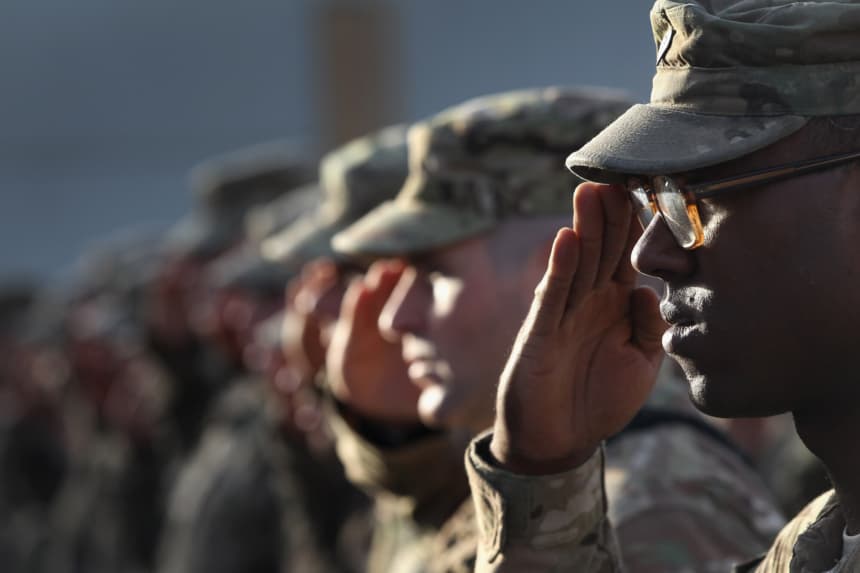 Soldados del Ejército de EE. UU. saludan durante el himno nacional. (John Moore/Getty Images)