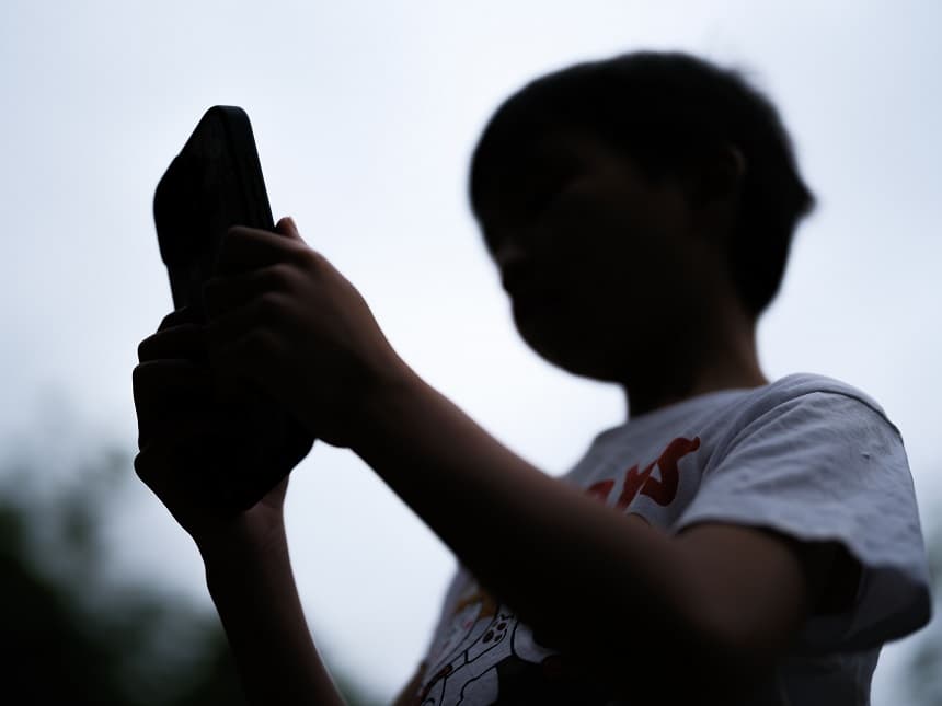 Un niño de 7 años mira la pantalla de un teléfono el 7 de diciembre de 2025 en Sídney, Australia. (George Chan/Getty Images)