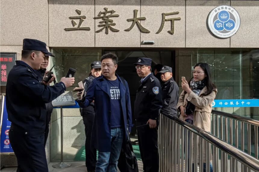 El abogado Xie Yang (centro) acompañaba a su clienta Xu Yan (derecha), esposa del abogado de derechos humanos Yu Wensheng, quien intentaba reunirse con Yu en persona frente al Tribunal Intermedio de Xuzhou, en la ciudad de Xuzhou, al este de la provincia de Jiangsu (China), el 31 de octubre de 2019. Nicolas Asfouri/AFP vía Getty Images