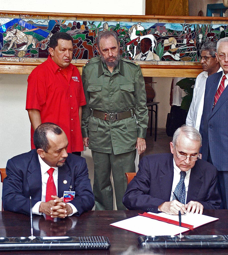 <em>El presidente venezolano Hugo Chávez (al fondo, izquierda) y el presidente cubano Fidel Castro (al fondo, derecha) observan la firma de documentos por parte de funcionarios del Banco Central de Cuba y del Banco Industrial de Venezuela el 28 de abril de 2005 en La Habana. La petrolera estatal venezolana PDVSA (Petróleos de Venezuela) explorará, extraerá y refinará petróleo de las zonas económicas del Golfo de México, anunció la compañía, lo que representa un posible beneficio para el presidente comunista cubano Fidel Castro. (Foto: ERNESTO MASTRASCUSA/AFP vía Getty Images)</em>