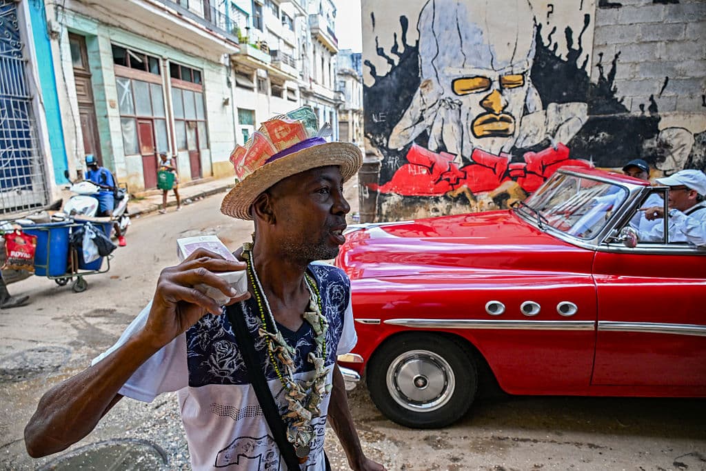 <em>Un hombre lleva un sombrero decorado con billetes que muestran imágenes del guerrillero argentino Ernesto "Che" Guevara mientras camina por una calle de La Habana el 26 de marzo de 2026. (Foto de YAMIL LAGE / AFP vía Getty Images)</em>