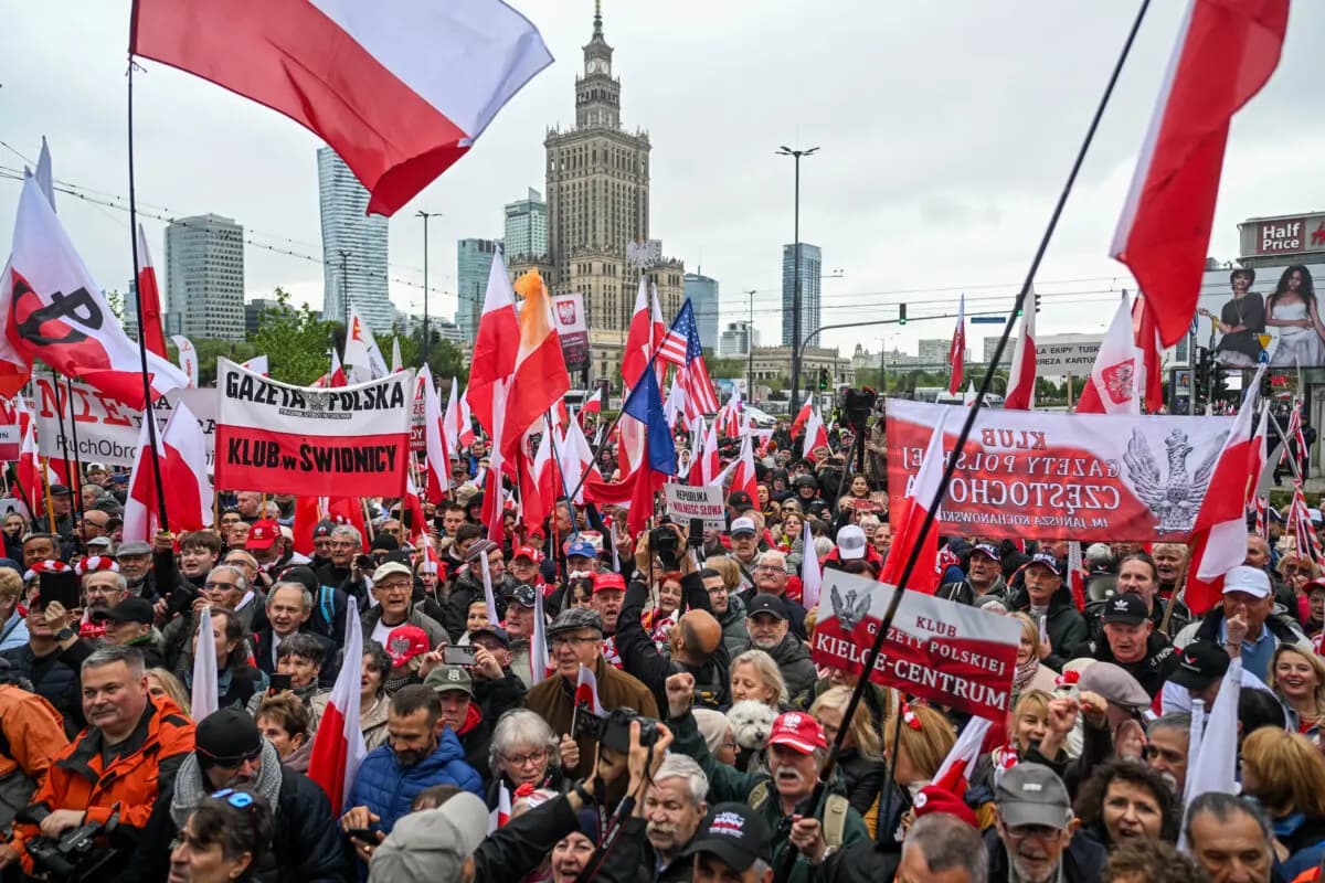 La gente sostiene pancartas y la bandera nacional polaca durante una protesta contra la inmigración, en Varsovia, Polonia, el 10 de mayo de 2025. (Omar Marques/Getty Images)