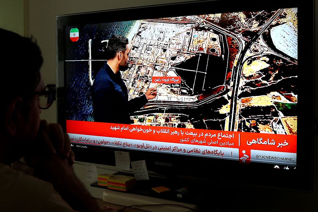 <em>Un hombre iraní ve las noticias en la televisión estatal iraní (IRIB) en Teherán el 23 de marzo de 2026. Irán ha publicado mapas de las centrales eléctricas que amenazó con atacar en la región, en respuesta al ultimátum del presidente estadounidense para que la república islámica reabriera el vital estrecho de Ormuz. Trump amenazó con "aniquilar" las centrales eléctricas de Irán si no reabriera el estratégico paso. El 28 de febrero, Israel y Estados Unidos lanzaron ataques contra Irán, matando a su líder supremo y desencadenando una guerra que se extendió por todo Oriente Medio, desatando el caos en los mercados mundiales y disparando los precios del petróleo. (Foto de AFP vía Getty Images)</em>