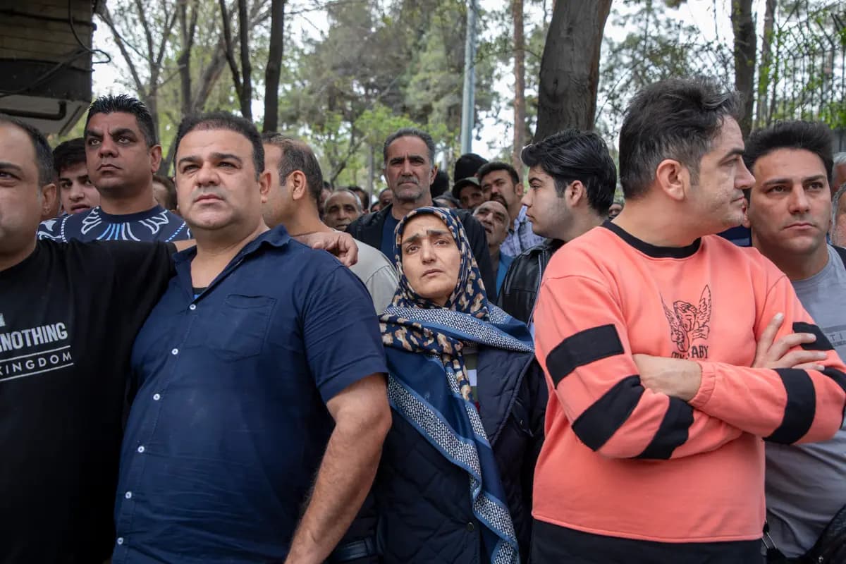 <em>Civiles observan mientras los rescatistas buscan cuerpos entre los escombros de un edificio residencial tras un ataque aéreo en Teherán el 27 de marzo de 2026. (Majid Saeedi/Getty Images)</em>