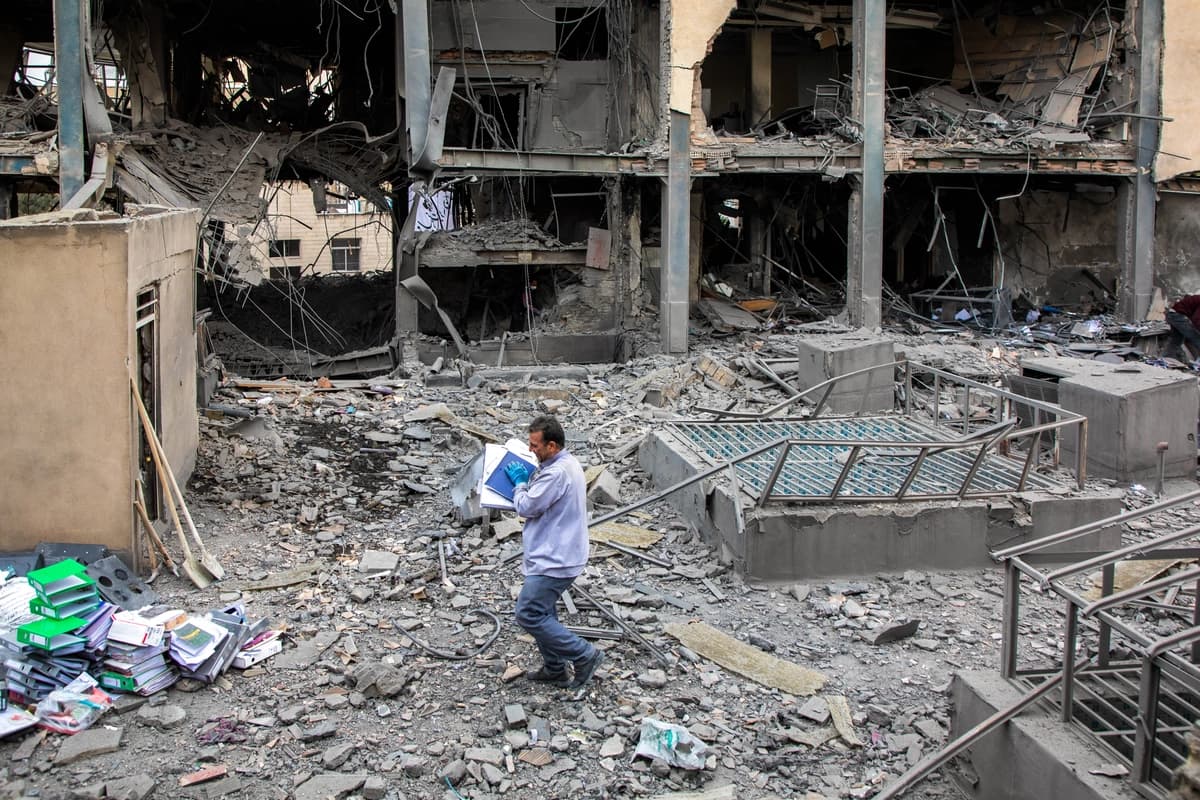 Personas recogen objetos en el lugar donde se produjo un ataque conjunto de Estados Unidos e Israel contra un distrito comercial el 29 de marzo de 2026 en Teherán, Irán. (Foto de Majid Saeedi/Getty Images)