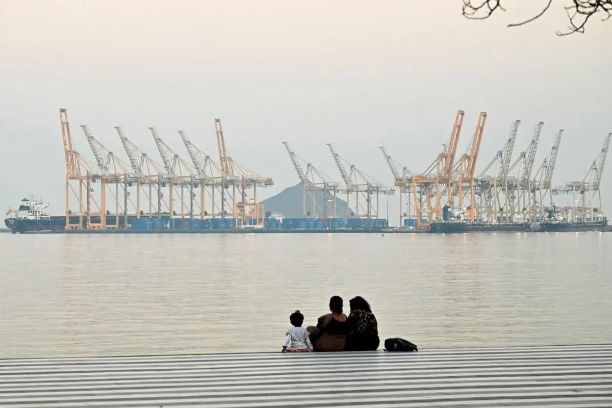 Una familia posa con un astillero de fondo en Fujairah, en el estrecho de Ormuz, en los Emiratos Árabes Unidos, el 25 de febrero de 2026. (Giuseppe Cacace/AFP vía Getty Images)