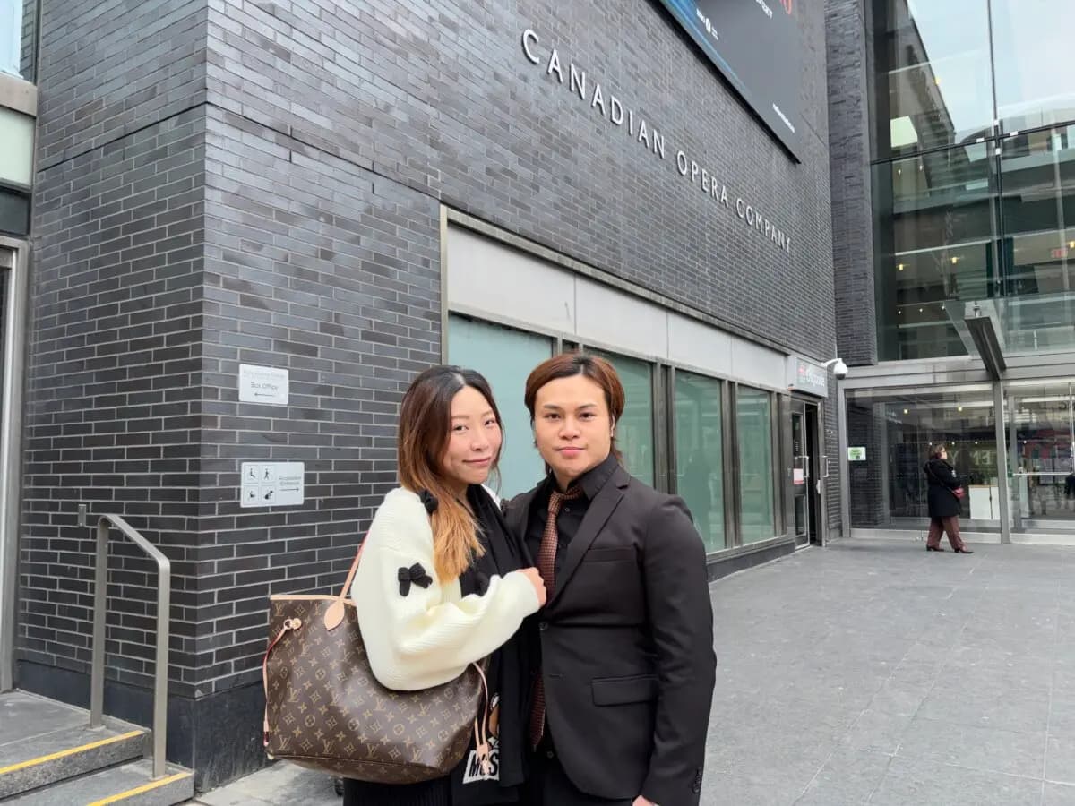 Kui Teng, campeón de kickboxing de Hong Kong, y su esposa frente al Four Seasons Centre for the Performing Arts de Toronto, donde Shen Yun tenía previsto actuar, el 1 de abril de 2026. (Teng Dongyu/The Epoch Times)