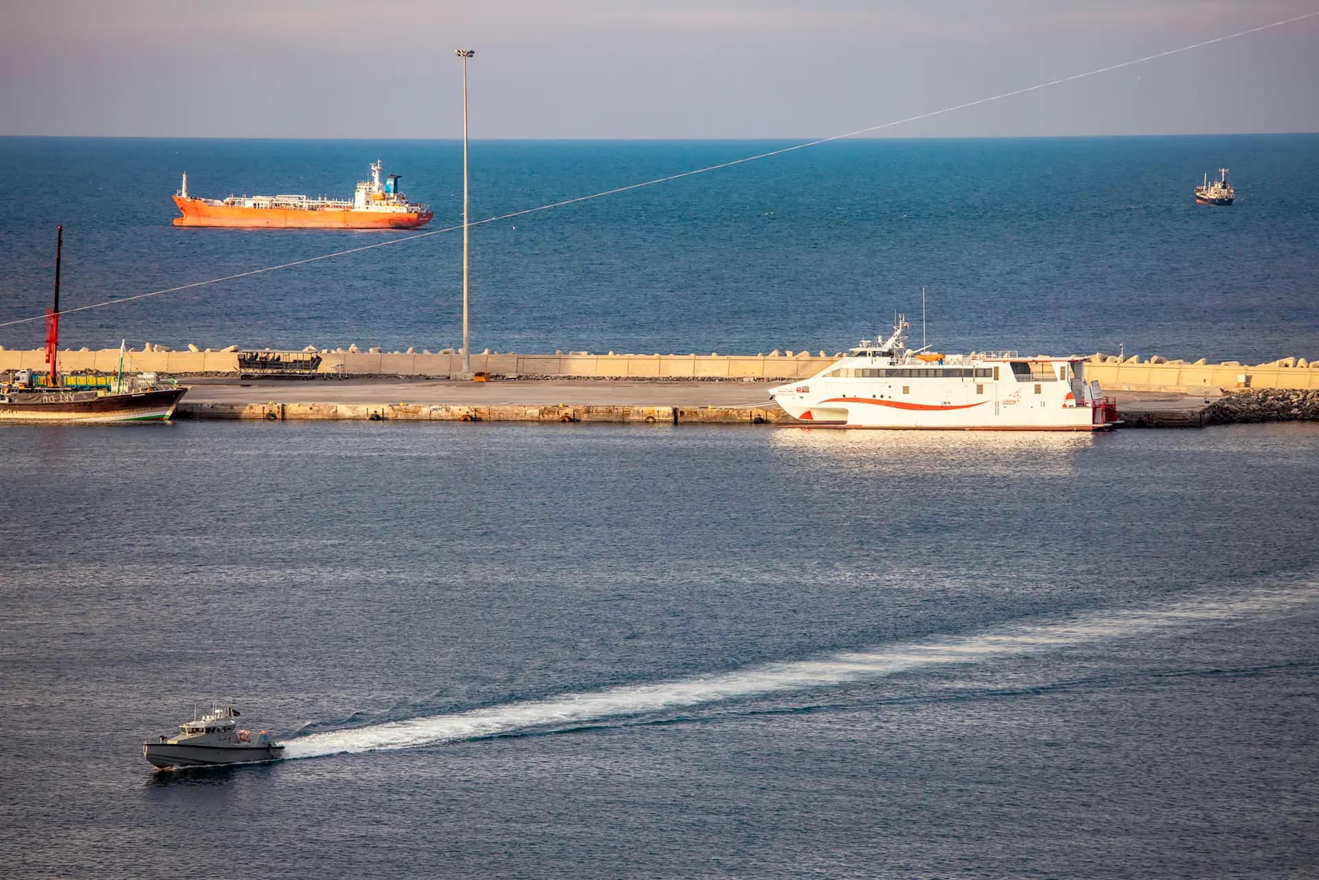Una lancha rápida de la policía patrulla el puerto mientras petroleros y embarcaciones de alta velocidad permanecen anclados cerca del estrecho de Ormuz en Mascate, Omán, el 30 de marzo de 2026. Los ataques de Irán contra buques comerciales interrumpieron el tráfico a lo largo de esta vía marítima vital, que anteriormente transportaba alrededor del 25 por ciento del comercio mundial de petróleo por vía marítima, según la Agencia Internacional de Energía. (Elke Scholiers/Getty Images)