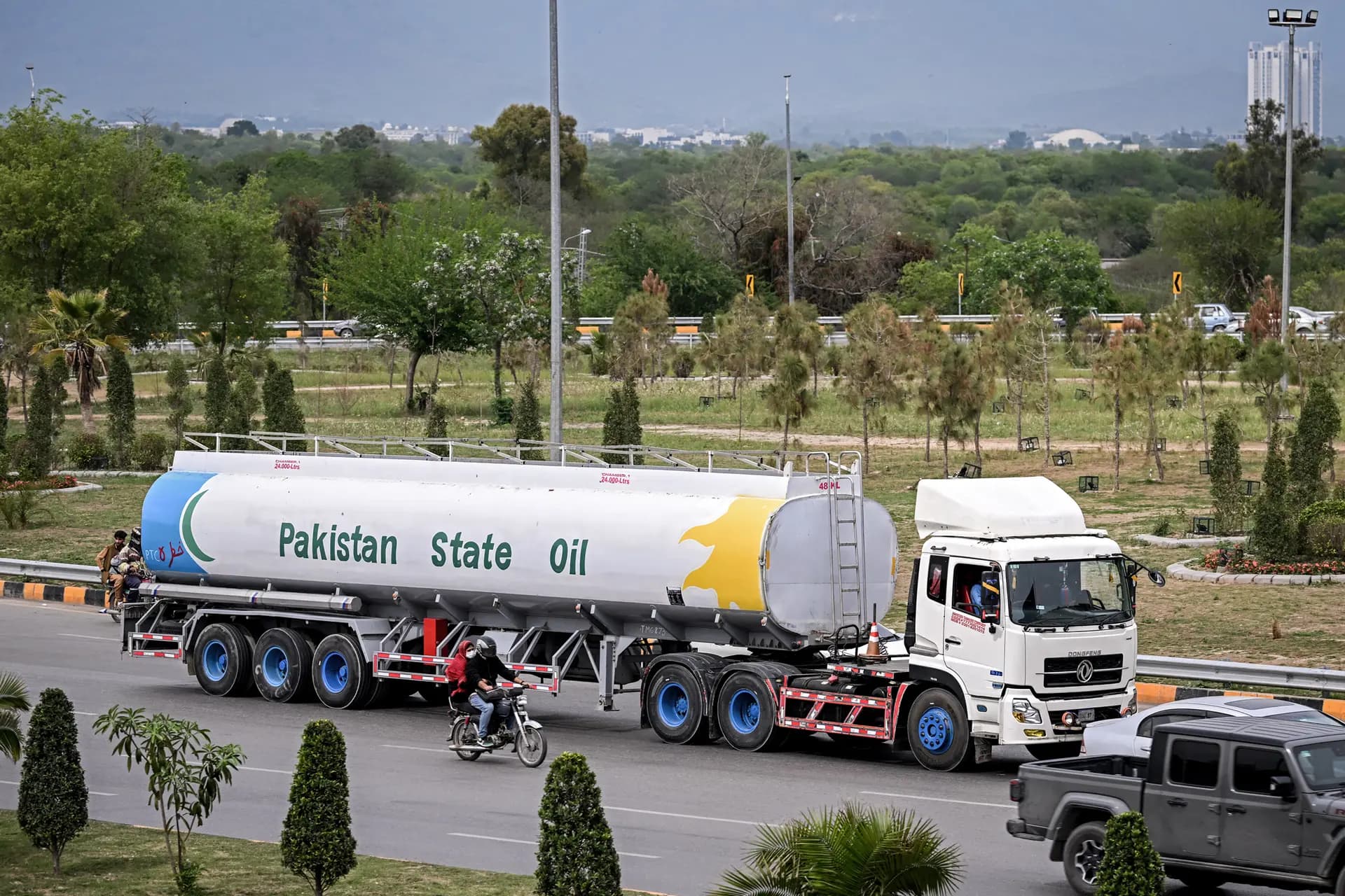 El 28 de marzo de 2026, varios viajeros pasan junto a un camión cisterna en una calle de Islamabad. El crudo Brent, la referencia mundial del petróleo, ha superado los 100 dólares por barril, mientras que el precio de la gasolina ha subido por encima de los 4 dólares por galón. (Farooq Naeem/AFP vía Getty Images)
