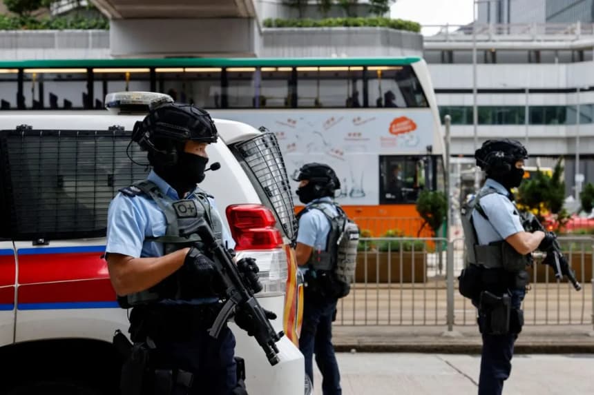 Policías armados montan guardia mientras escoltan un furgón policial que se cree que transporta al magnate de los medios Jimmy Lai, fundador de Apple Daily, a la Corte Superior de Hong Kong, el 1 de diciembre de 2022. (Tyrone Siu/Reuters)