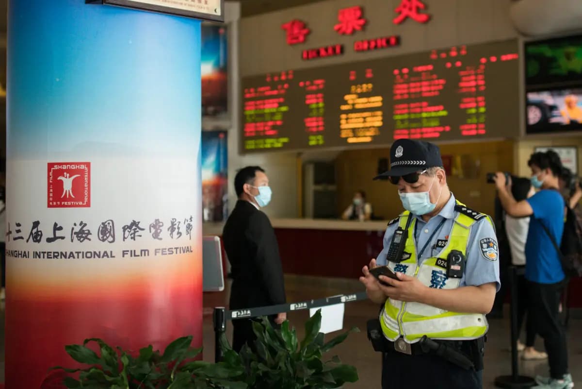Un oficial de policía mira su teléfono celular en el Shanghai Film Center en Shanghai el 25 de julio de 2020. (Imágenes de Yifan Ding/Getty)