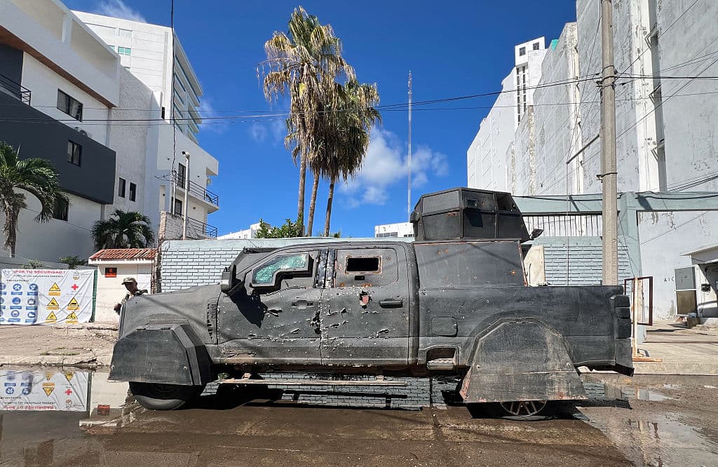 <em>Un vehículo blindado modificado por el crimen organizado frente a la subdelegación de la Fiscalía General de la República en Mazatlán, Sinaloa, México, el 23 de agosto de 2025. En Sinaloa, los muertos y desaparecidos se cuentan por miles y la economía se ha derrumbado, un año después del inicio de la guerra entre narcotraficantes. (Foto de MARCOS VIZCARRA/AFP vía Getty Images)</em>