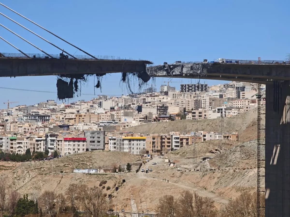 Hormigón y barras de refuerzo cuelgan de un puente B1 dañado, un día después de que fuera destruido por un ataque aéreo, al oeste de Teherán, en Karaj, Irán, el 3 de abril de 2026. (Majid Saeedi/Getty Images)