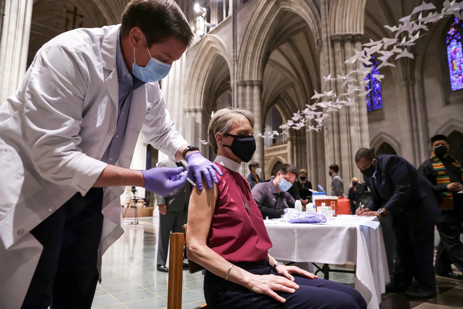 Un profesional sanitario distribuye dosis contra COVID-19 en una campaña de vacunación pública celebrada en la Catedral Nacional de Washington, el 16 de marzo de 2021. (Alex Wong/Getty Images).