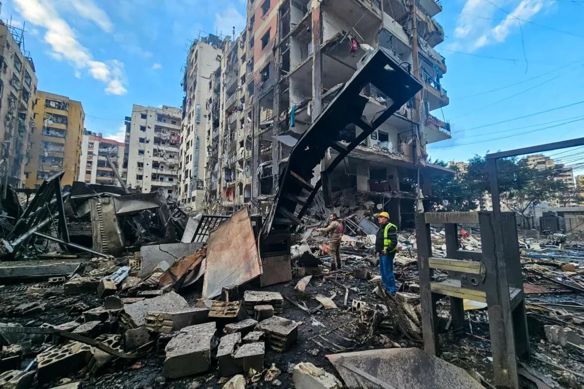 Unos hombres inspeccionan el lugar donde se produjeron los ataques aéreos israelíes durante la noche en los suburbios del sur de Beirut el 16 de marzo de 2026. (AFP vía Getty Images)