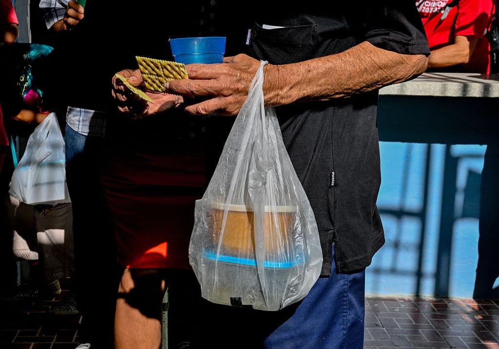 <em>Un feligrés anciano lleva una bolsa tras recibir una comida gratuita en la Iglesia Bautista Nazaret, en el barrio de La Víbora, La Habana, el 14 de abril de 2026. Tres veces por semana, unas 400 personas, en su mayoría feligreses ancianos de escasos recursos, acuden a esta iglesia para asistir a los servicios religiosos, hacer ejercicio, compartir el almuerzo y recibir atención médica, en medio de la grave crisis económica que atraviesa Cuba. (Foto de Adalberto Roque / AFP vía Getty Images)</em>