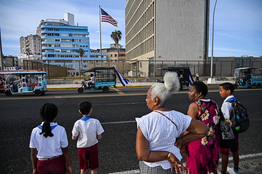 <em>Cubanos en triciclos eléctricos decorados con banderas cubanas pasan frente a la embajada de Estados Unidos durante la marcha juvenil antiimperialista en La Habana el 2 de abril de 2026. (Foto de YAMIL LAGE / AFP vía Getty Images)</em>