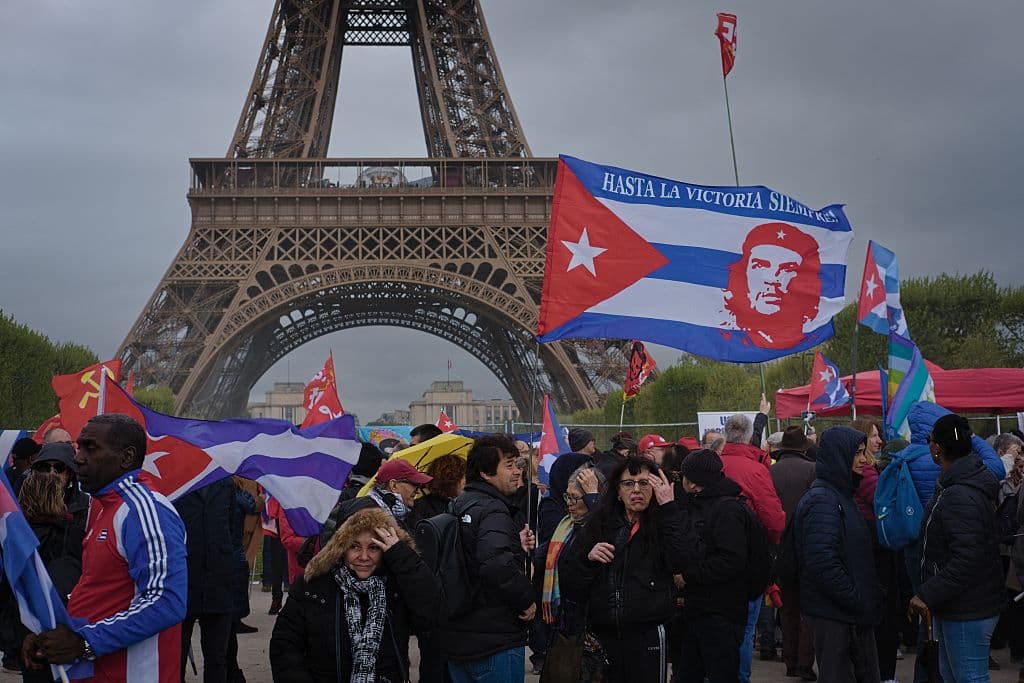 <em>Personas alzan una bandera cubana con la imagen del Che Guevara durante una manifestación contra el bloqueo estadounidense de Cuba cerca de la Torre Eiffel en París, Francia, el 11 de abril de 2026. La manifestación, organizada por el Partido Comunista Francés (PCF) y grupos de solidaridad, generó una movilización política con pancartas, banderas y lemas en apoyo de la soberanía cubana. (Foto de Djoudi Hamani/Hans Lucas/AFP vía Getty Images)</em>