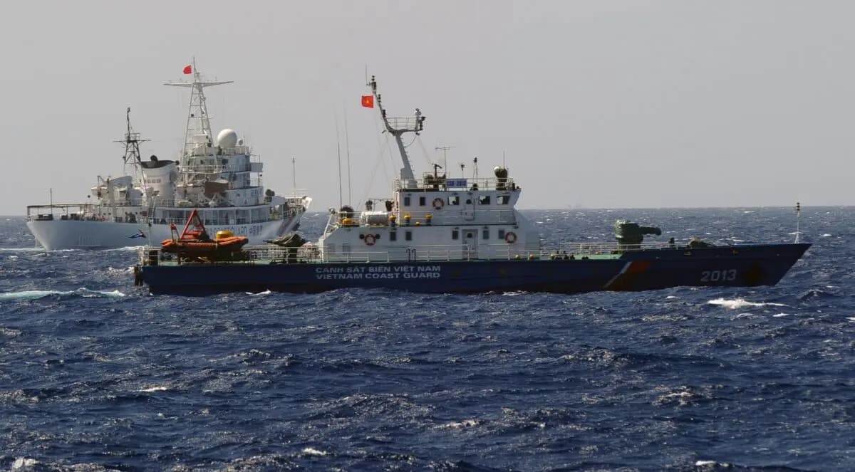 Un barco de la Guardia Costera de China (izquierda) persigue a una embarcación de la Guardia Costera de Vietnam cerca del lugar donde se está instalando una plataforma petrolífera china en las aguas en disputa del Mar de China Meridional, frente a la costa central de Vietnam, el 14 de mayo de 2014. (Hoang Dinh Nam/AFP vía Getty Images)