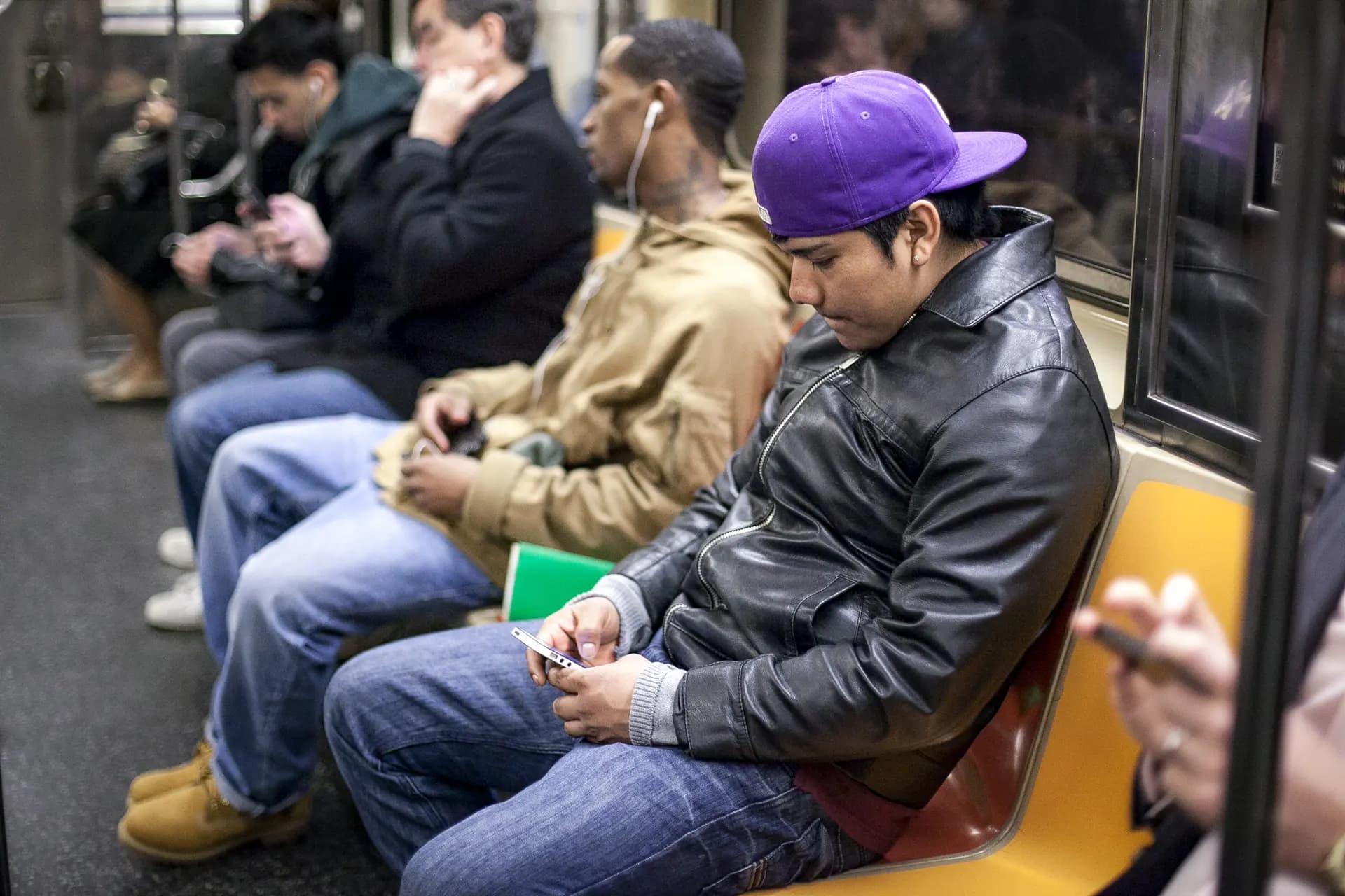 La gente mira sus teléfonos en el metro de Nueva York el 1 de abril de 2014. (Samira Bouaou/The Epoch Times)