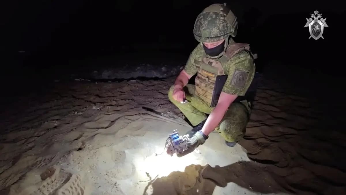 Un oficial del Comité de Investigación de Rusia examina los restos de un dron en una playa tras lo que las autoridades locales calificaron como un ataque con drones ucranianos, en esta imagen fija extraída de un video difundido el 9 de julio de 2025. (Comité de Investigación de Rusia/Imagen facilitada a través de Reuters).