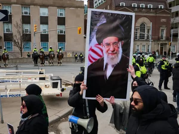 Unos manifestantes sostienen un retrato del antiguo líder supremo iraní, el ayatolá Alí Jamenei, mientras se concentran frente al consulado de EE. UU. durante una manifestación con motivo del Día de Al-Quds, en Toronto, Canadá, el 14 de marzo de 2026. (Sammy Kogan/The Canadian Press).