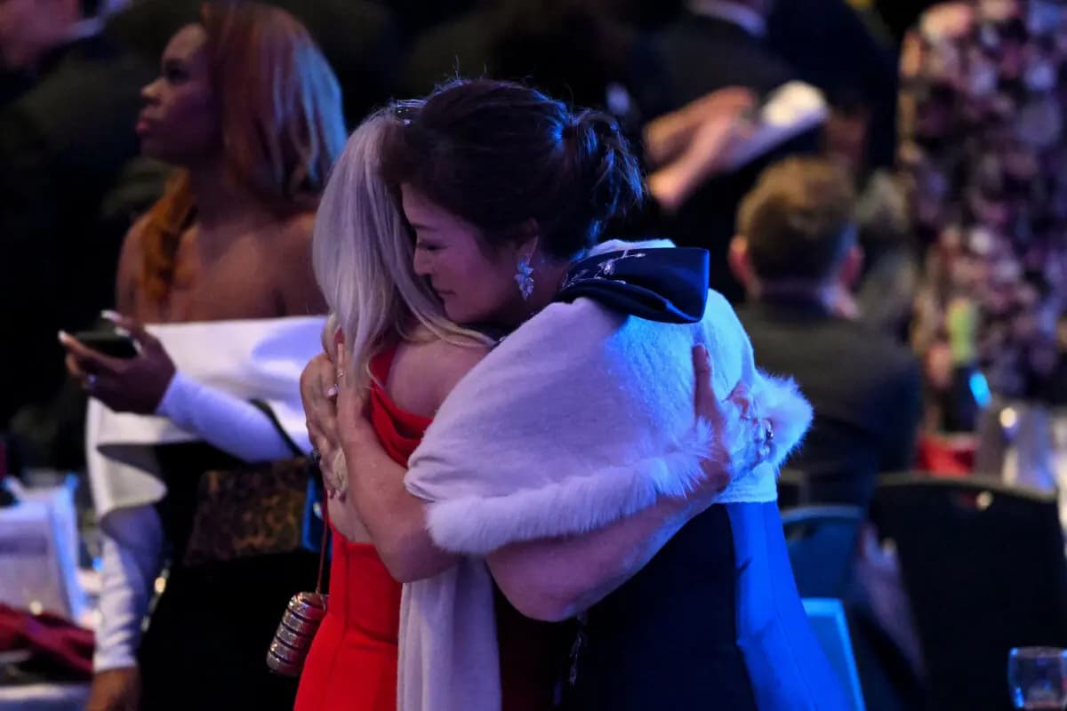 <em>Los asistentes se abrazan dentro del salón de baile después de que, según los informes, se efectuaran disparos durante la cena de corresponsales de la Casa Blanca en el Washington Hilton en Washington, D.C., el 25 de abril de 2026. (Mandel NGAN / AFP vía Getty Images).</em>