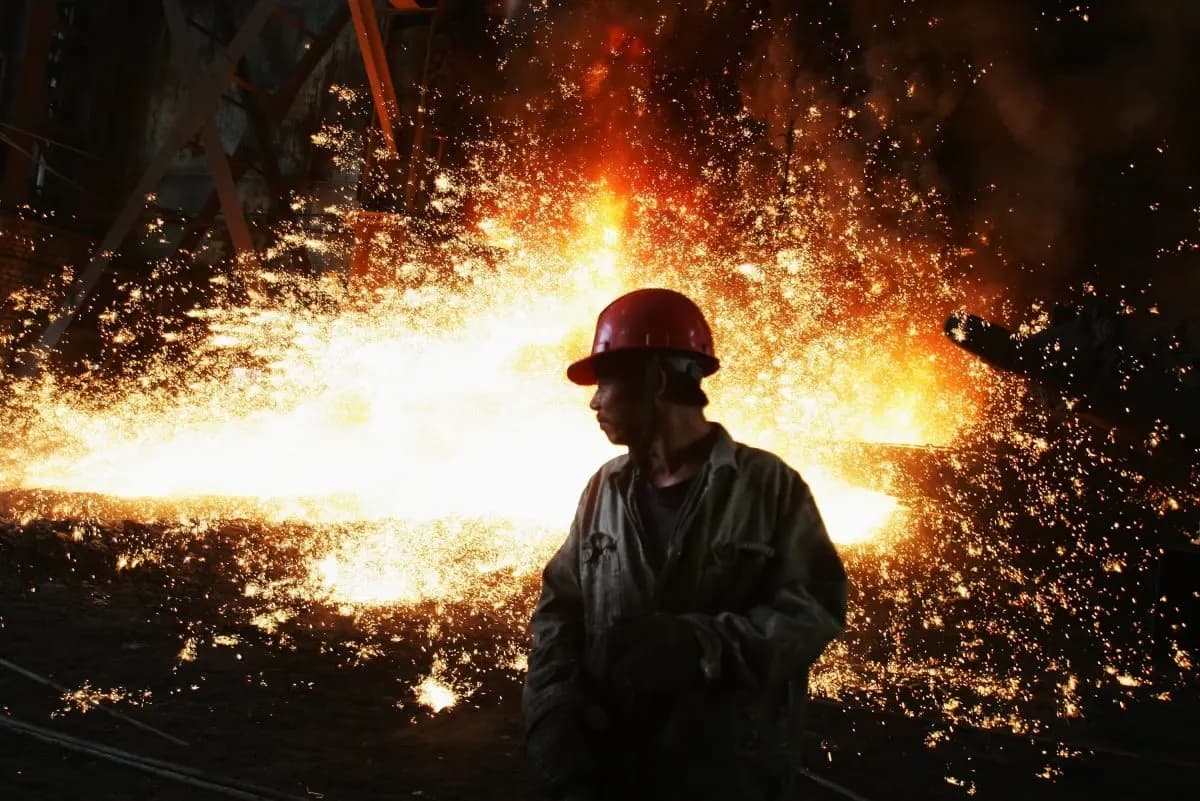 Un trabajador junto a un chorro de hierro fundido en el taller de fundición de la planta siderúrgica de Chengde, en la ciudad de Chengde, provincia de Hebei (China), el 11 de octubre de 2007. (Feng Li/Getty Images)