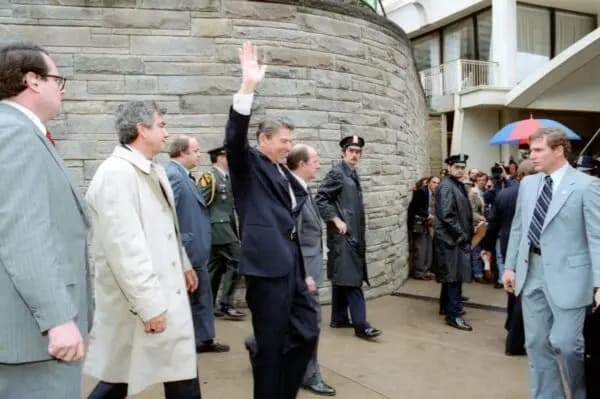 El presidente Ronald Reagan (C) saluda con la mano justo antes de recibir un disparo frente a un hotel de Washington el 30 de marzo de 1981. (Dominio público)