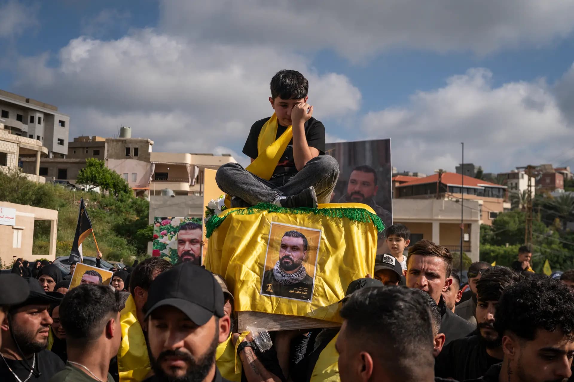 El hijo de un combatiente de Hezbolá asesinado se sienta sobre el ataúd de su padre mientras este es transportado durante una ceremonia fúnebre en Sammaaiyeh, Líbano, el 29 de abril de 2026. (Adri Salido/Getty Images).