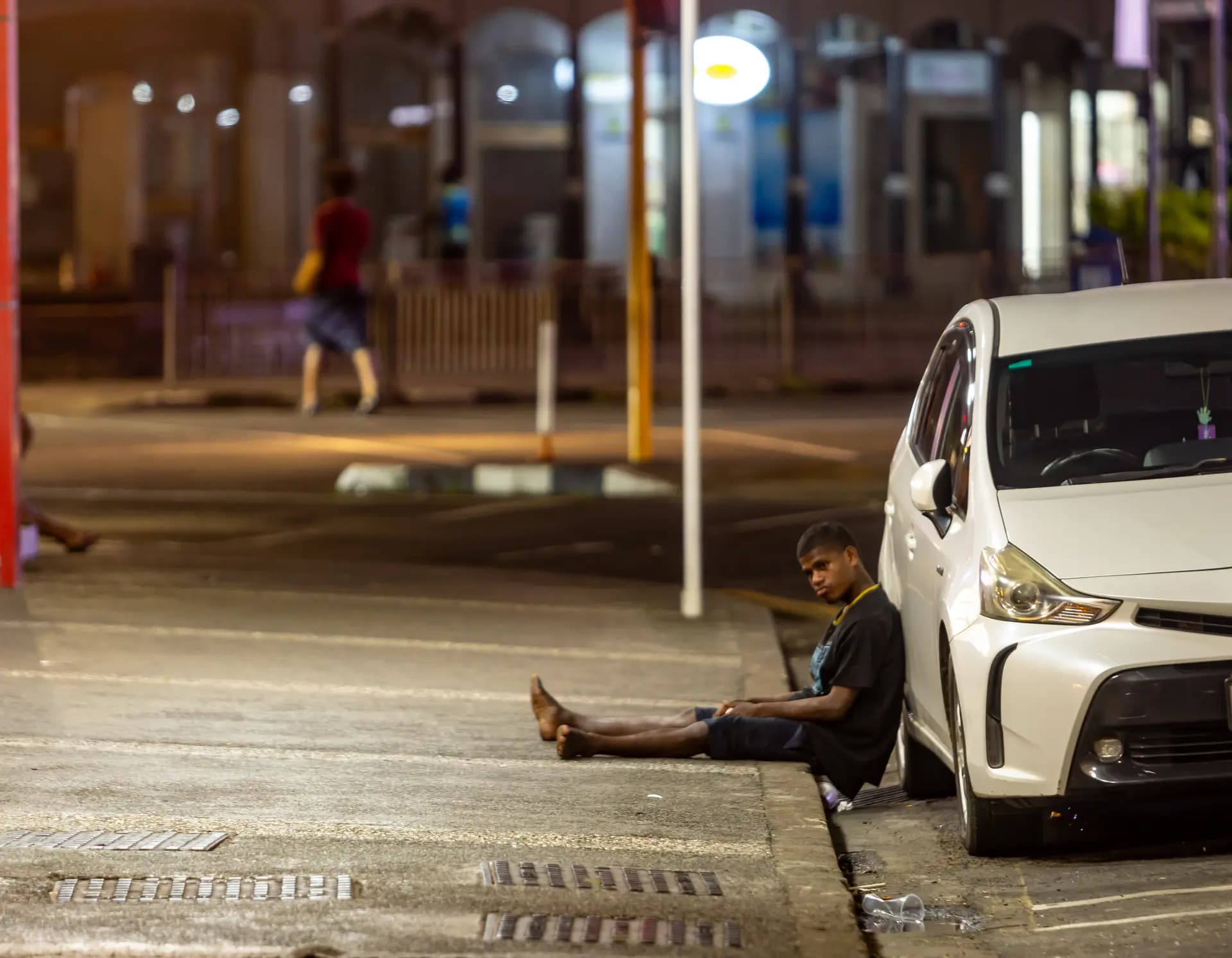 Un joven está sentado en el borde de la acera en las calles de la ciudad de Suva, en Fiyi, el 29 de abril de 2026. (Pita Simpson/Getty Images).