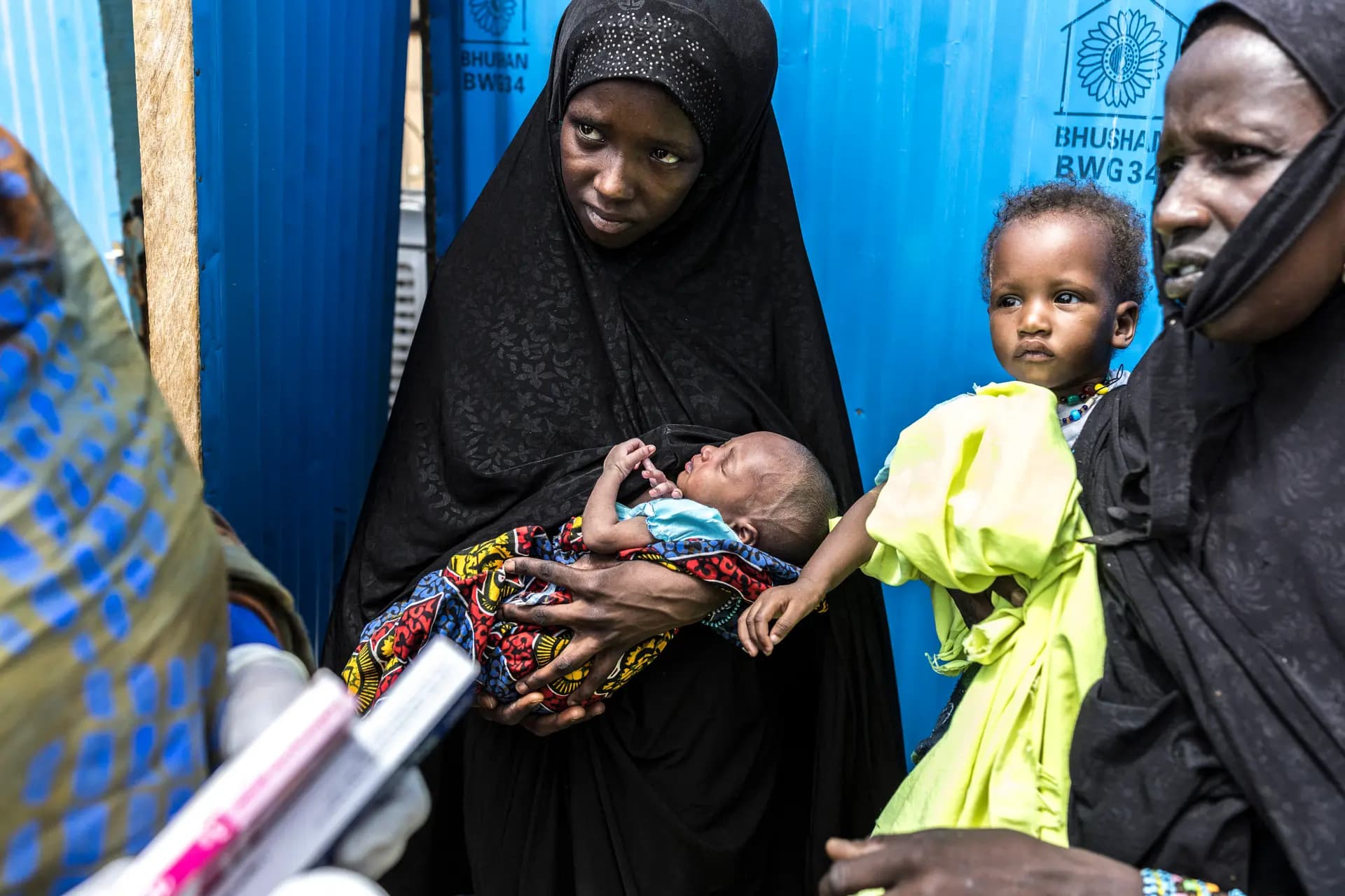 Una refugiada (C) sostiene a su bebé recién nacido mientras escucha a un trabajador sanitario en un centro de salud de Médicos Sin Fronteras en Doueinkara, cerca de la frontera de Mauritania con Malí, el 29 de abril de 2026. Miles de personas han perdido la vida en los ataques perpetrados en Mali desde que estalló la agitación yihadista y decenas de miles de malienses han buscado refugio en países vecinos, incluida Mauritania, en los últimos años. (Patrick Meinhardt/AFP vía Getty Images).