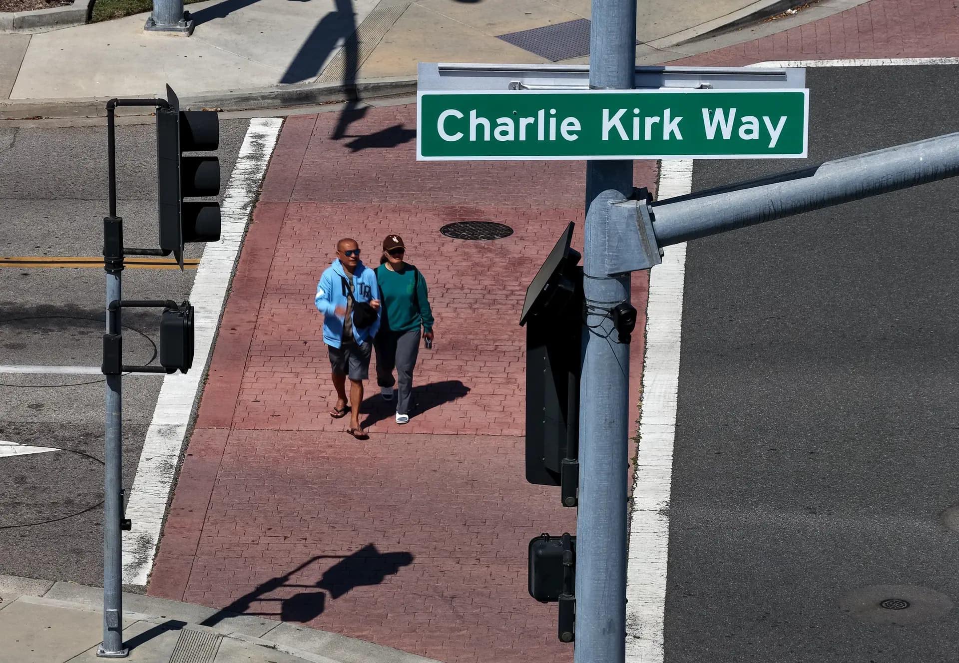 Unos peatones pasan junto a un letrero recién instalado con el nombre "Charlie Kirk Way" en Westminster, California, el 29 de abril de 2026. La ciudad de Westminster se convirtió en la primera del país en dedicar una calle al fallecido activista conservador y podcaster Charlie Kirk, quien fue asesinado a tiros en 2025; el letrero se ha instalado cerca de Westminster Boulevard y All American Way. (Justin Sullivan/Getty Images).