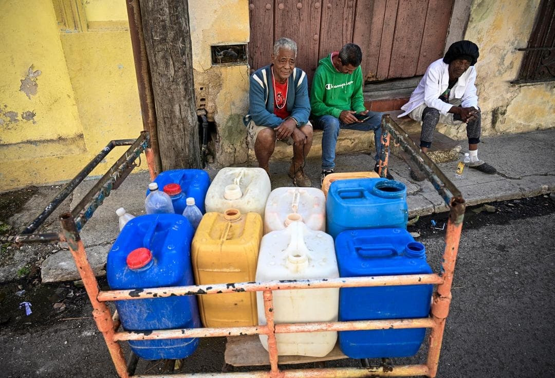 La gente hace fila para llenar sus recipientes de agua durante un apagón a nivel nacional en La Habana el 22 de marzo de 2026. Las autoridades cubanas se apresuraron el 22 de marzo a restablecer el suministro eléctrico en la isla tras el segundo apagón a nivel nacional en menos de una semana, mientras la red eléctrica se ve afectada por una infraestructura envejecida y el bloqueo petrolero de EE. UU. (Yamil Lage/AFP vía Getty Images)