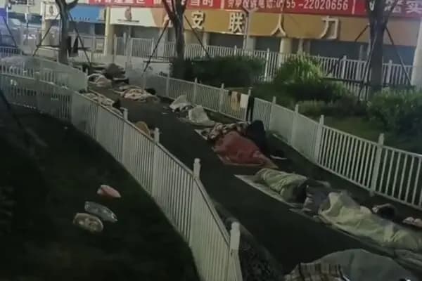 Las personas que no pueden encontrar trabajo duermen en las calles en una noche de invierno en Shenzhen a finales de 2025. (Captura de pantalla del vídeo de The Epoch Times)